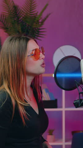 Attractive successful youth modern duet of pretty girl and bearded guy rehearsing new song before joint performance,girl singing in front of microphone ,guy playing on the guitar