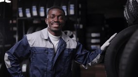 Tire at repairing service garage, African male adult mechanic inspecting tyre in auto shop. - Powered by Shutterstock - Get 15% off with code: PIKWIZARD15