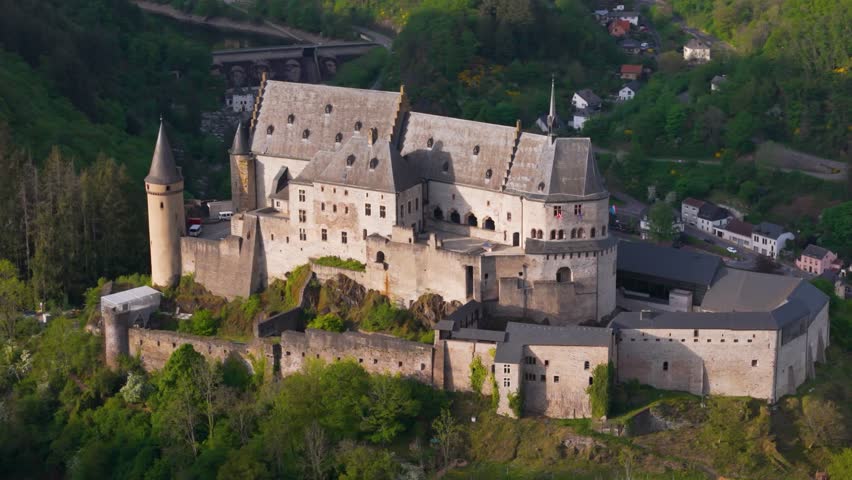 walls domes murals bridge vianden castle chateau de historic site green hills cloudy skies overlooks homes to from left near right afar circling drone luxembourg