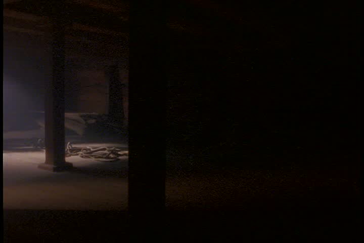 Historical reenactment of an old slave ship in Connecticut.  WS very dark, smoky slave hold, camera pans left to stairs with some sun streaming in. 