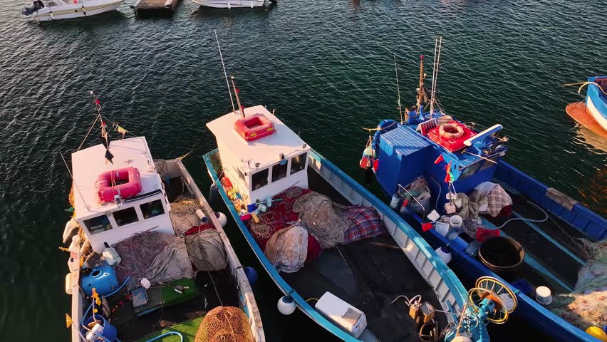 Aerial view of isola Rossa with its colorful buildings, marina filled with boats, and rocky coastline meeting the turquoise sea, isola Rossa, Sardinia, italy.