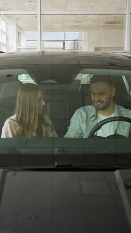 Happy couple choosing new car at dealership