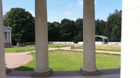 Aerial Glide Past White Columned Walkway Landscaped