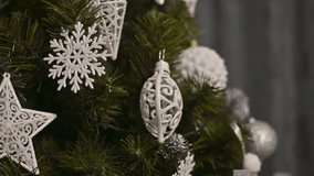 Closeup of Christmas ornaments on pine tree branches, featuring silver stars and snowflakes. Christmas ornaments with delicate snowflakes and stars hang on green pine branches.Christmas tree at home - Powered by Shutterstock - Get 15% off with code: PIKWIZARD15