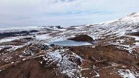 A snowy mountain range with a large body of water in the middle. The water is frozen and the sky is cloudy - Powered by Shutterstock - Get 15% off with code: PIKWIZARD15