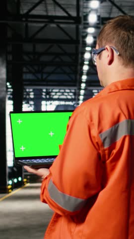 Vertical Video Mockup screen laptop with supervisor oversees construction and production tasks, surrounded by industrial machinery, metal tools and engineering elements that support strong manpower