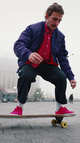 Full length rear view of young man skateboarding while hanging out at the city square outdoors. Find your freedom.