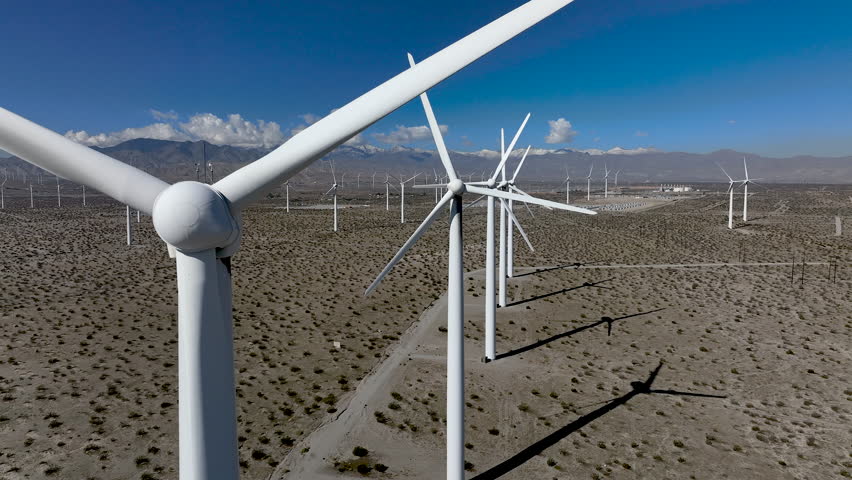 Wind Turbines - Static shot of wind turbines operating in the San Gorgonio Pass near Palm Springs, California. Renewable energy infrastructure in a desert mountain landscape under clear skies.