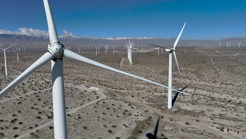Wind Turbines - Static shot of wind turbines operating in the San Gorgonio Pass near Palm Springs, California. Renewable energy infrastructure in a desert mountain landscape under clear skies.