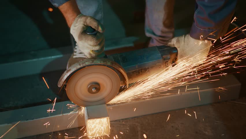 metal piece sparks fly everywhere, wheel sparks illuminate workshop as metal is cut, sparks from grinding wheel scatter across workshop floor during metal cutting