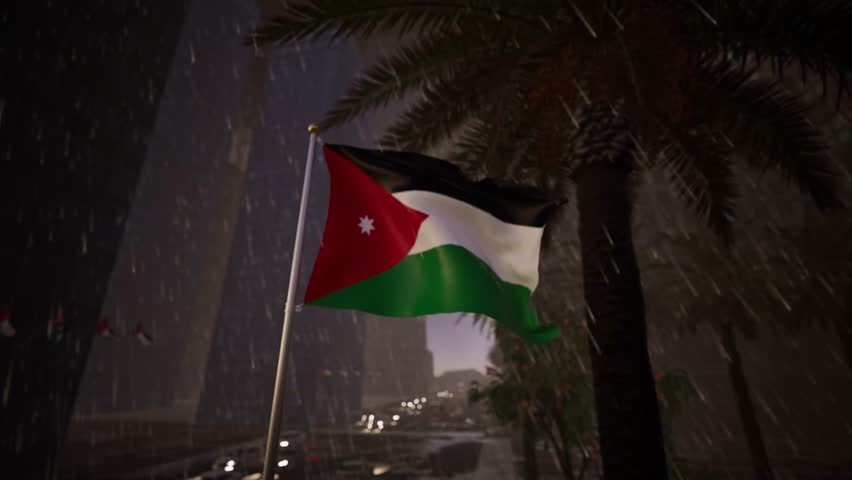 Jordan national flag waving in heavy rainfall across a modern city street with wet reflective surfaces, palm trees and moving traffic. The atmosphere is intense as precipitation hammers down on the Hashemite banner. Droplets cascade over the nylon material, darkening the shades of the red, black, white, and green colors. The weight of the moisture alters the movement of the textile, causing it to heave and sway with a heavy, deliberate rhythm rather than a light flutter. This scene captures the resilience of the nation, symbolized by the emblem enduring the storm. The background is a wash of grey mist and downpour, softening the outlines of the Amman skyline. Puddles on the asphalt mirror the streetlights and the gloomy sky, creating a slick, cinematic look. The standard sheds water with every oscillation, sending spray into the air. The white seven-pointed star remains visible, a beacon amidst the deluge. Vehicles navigate the flooded roads, their tires kicking up mist as they pass. The ensign struggles against the wet wind, demonstrating the durability of the fabric. This footage is perfect for weather reports, metaphorical content about overcoming hardship, or dramatic news sequences. The pendant hangs lower than usual due to the saturation but continues to fly. The surrounding vegetation droops slightly under the torrent, adding to the realism of the weather event. Condensation builds on the metal pole before trickling down. The cloth appears glossy and slick, reflecting the ambient light of the urban environment. The visual captures the raw power of nature interacting with the symbol of the kingdom. The showers are relentless, creating a texture of vertical lines across the frame.