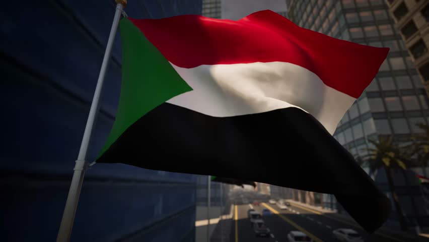 Sudan national flag waving along a modern city street under clear daylight, surrounded by buildings, palm trees and light traffic within an urban environment. This vibrant textile emblem features three horizontal stripes of red, white, and black, punctuated by a green triangle at the hoist, symbolizing the rich history and agricultural wealth of this North African nation. The fabric undulates rhythmically against a backdrop of blue skies and architectural structures typical of Khartoum, perhaps near the confluence of the Blue and White Nile. Sunlight catches the weave of the cloth, highlighting the vivid saturation of each hue while the metallic mast stands rigid against the breeze. In the distance, the silhouette of landmarks like the Corinthia Hotel or nearby government edifices adds context to the scene, grounding the visual in a specific geographic reality. As the pennant snaps and ripples, it evokes feelings of patriotism suitable for Independence Day or National Day broadcasts. The surrounding metropolis bustles with life, evidenced by the blur of passing sedans and taxis on the asphalt below. Palm fronds sway gently, mirroring the motion of the national standard, creating a harmonious interplay between nature and state symbolism. Shadows cast by high-rises stretch across the pavement, offering contrast to the brightness of the midday sun. This footage captures the essence of a developing capital, blending tradition with modernity as the ensign flies proudly. The material, likely a durable polyester or nylon mix, withstands the heat of the region, maintaining its form and color integrity. Viewers can observe the intricate stitching and the way the wind catches the fly end, creating a dynamic and continuous loop of movement that serves as a perfect establishing shot for news segments covering politics, economy, or travel documentaries focused on the Sahel region.