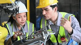 Industrial robot engineers, Male Mechanical Engineer and Female Chief Engineer Work Together safety helmet high visibility vest maintenance assembly electronics wiring industrial engineers factory  - Powered by Shutterstock - Get 15% off with code: PIKWIZARD15