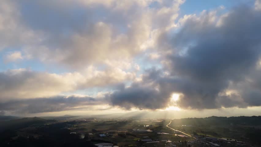 Drone panning above a thick cloud layer at sunrise, showing soft golden light and atmospheric mist.