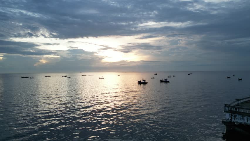 The horizon sunset, small fishing boats, fishing boats, expressed in gold, silver, blue, orange, and white.
