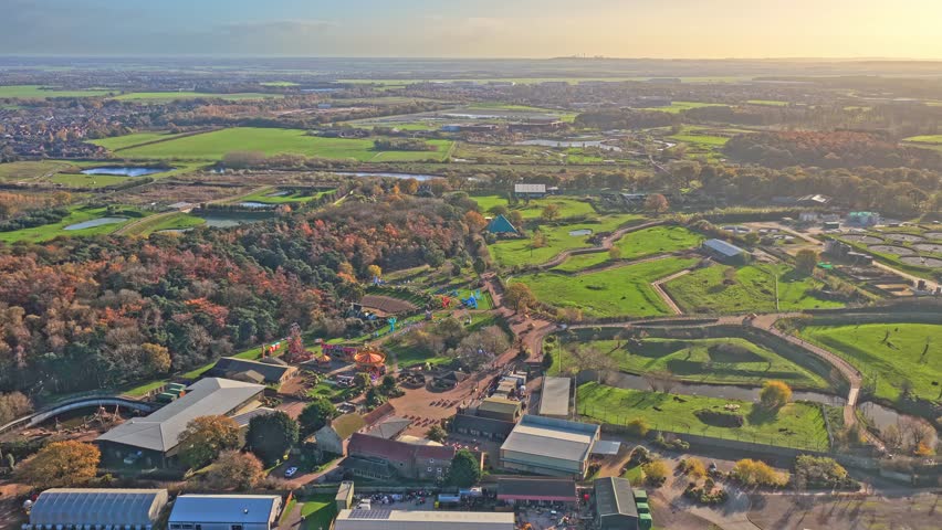 Aerial view of Yorkshire Wildlife Park and surrounding Branton countryside, showing enclosures, visitor buildings, ponds and autumn woodlands across expansive green fields