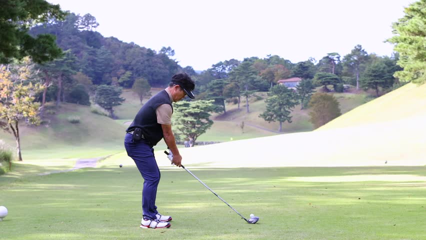 A middle-aged Japanese man enjoying golf