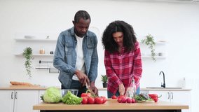 A smiling couple prepares a meal together in a bright, modern kitchen, chopping vegetables. - Powered by Shutterstock - Get 15% off with code: PIKWIZARD15