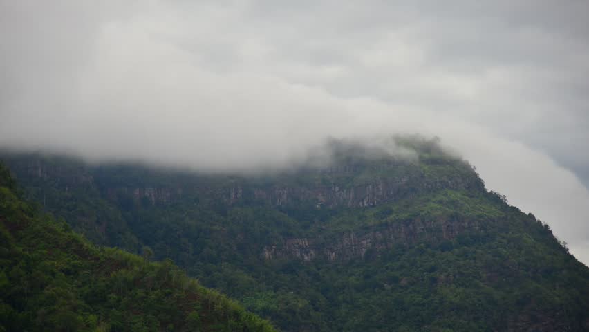 Aerial top view drone photo over green mountains with white fog floating and paths exciting steep road way of travel at Phu Thap Boek ,Phetchabun,Thailand.
