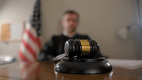 Close-up of a judge using a wooden gavel in a courtroom with the American flag in the background, showing justice, law, and legal proceedings. - Powered by Shutterstock - Get 15% off with code: PIKWIZARD15