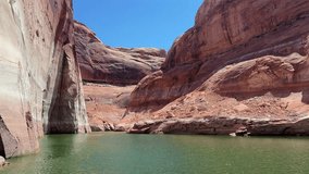 Slow, cinematic boat ride weaving through the towering red rock canyons of Lake Powell on a bright summer day, revealing calm water surrounded by dramatic sandstone walls. - Powered by Shutterstock - Get 15% off with code: PIKWIZARD15