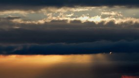 Dramatic dark storm clouds with golden sun rays breaking through at sunset. Cinematic slow motion sky background. - Powered by Shutterstock - Get 15% off with code: PIKWIZARD15