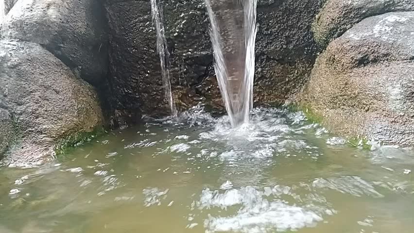 Close-up video of a natural flowing water garden decoration in a hospital garden in Jakarta.