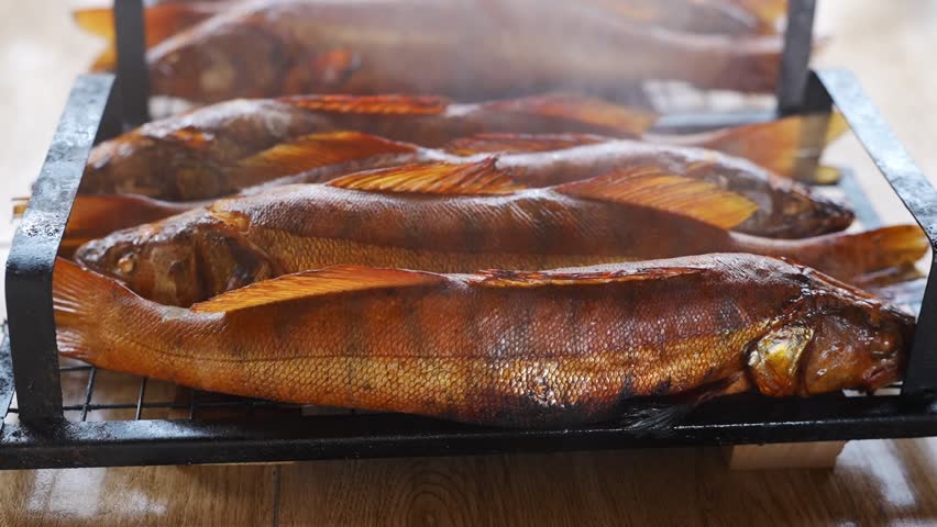 Cooking fresh fish on a grill creates a tasty meal with smoky flavors. Perfect for a summer gathering with friends and family outdoors.