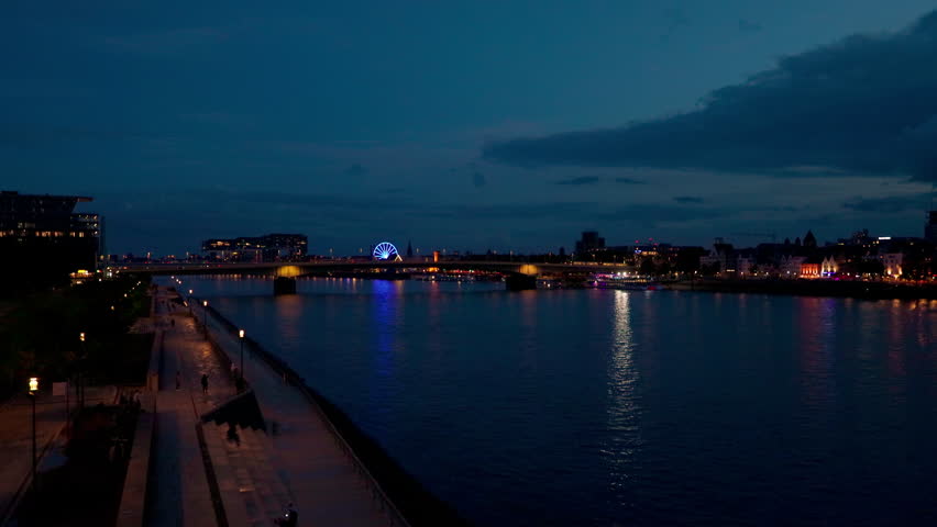 Cityscape of the Rhine River promenade and bridge at night in Cologne