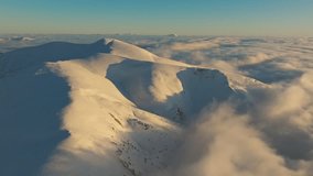 Sunlit mountain crest, Warm glow on snowy slopes, Soft clouds beneath illuminated mountain ridge, Golden evening light highlights snow contours on gentle slopes - Powered by Shutterstock - Get 15% off with code: PIKWIZARD15