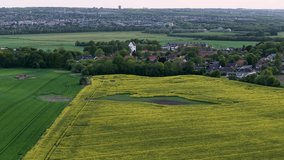 Drone footage of vibrant yellow mustard fields, green farmland and a small pond near the countryside of Aarhus, Denmark. - Powered by Shutterstock - Get 15% off with code: PIKWIZARD15