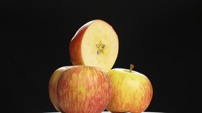Stack of fresh Royal Gala apples rotating on white background. Three whole fruits with a half-cut slice on top showing star-shaped core and seeds. - Powered by Shutterstock - Get 15% off with code: PIKWIZARD15