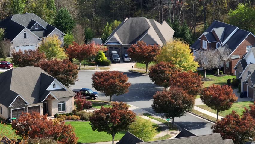 Cul-de-sac with colored trees and luxury mansions of american neighborhood. Aerial view. Noble villas in quiet and well-kept suburb neighborhood of town. Sunny day in fall season.