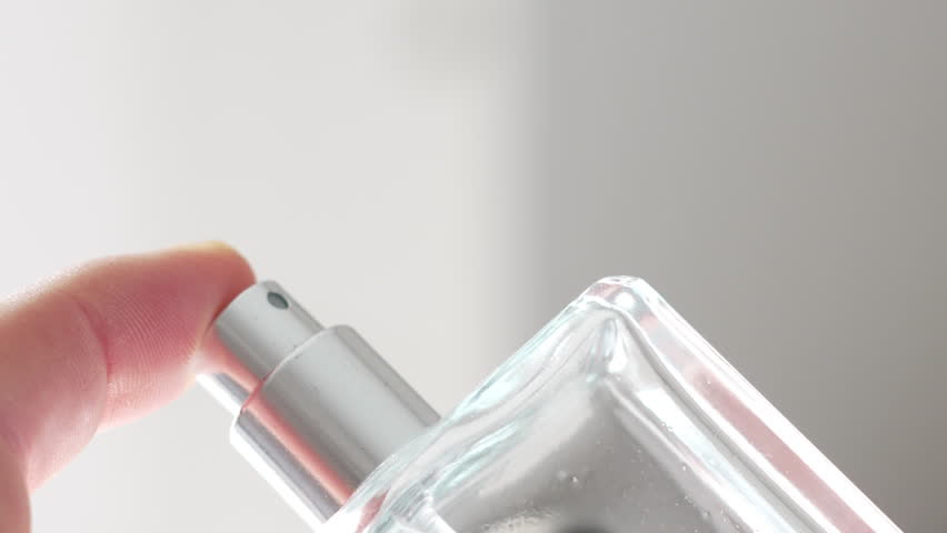 Finger Pressing Down on Cologne Spray Bottle to Release Fragrance in Slow Motion in Bright Naturally Lit Room. Elegant Perfume from a Bottle.