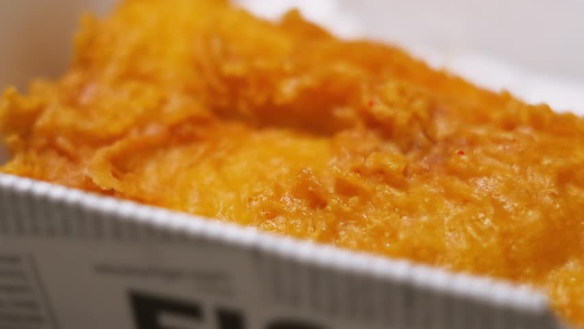 Side View of Crispy Delicious Battered Fish in Takeaway Box Ready to Eat. Delicious Fresh Cod Seafood Dinner Served in Britain.