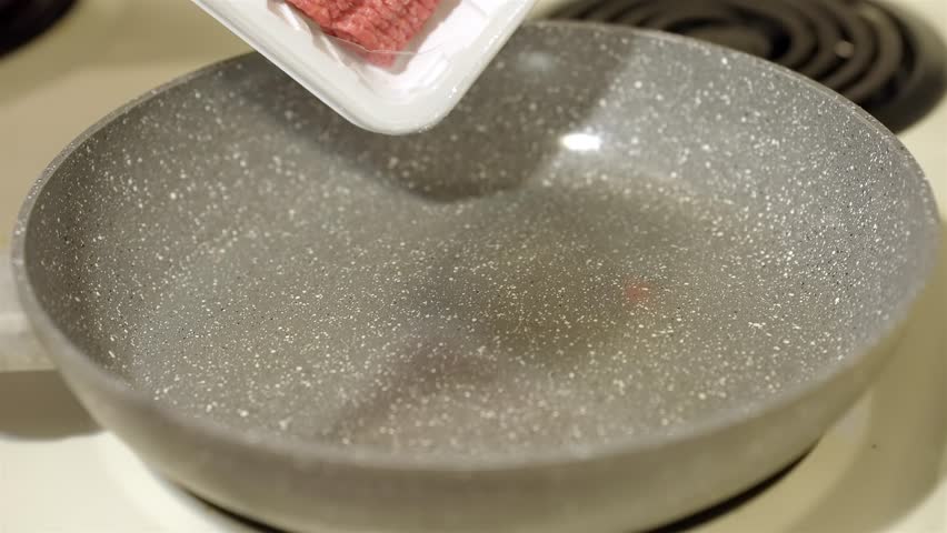Square of Raw Ground Beef Dropping into Frying Pan for Cooking