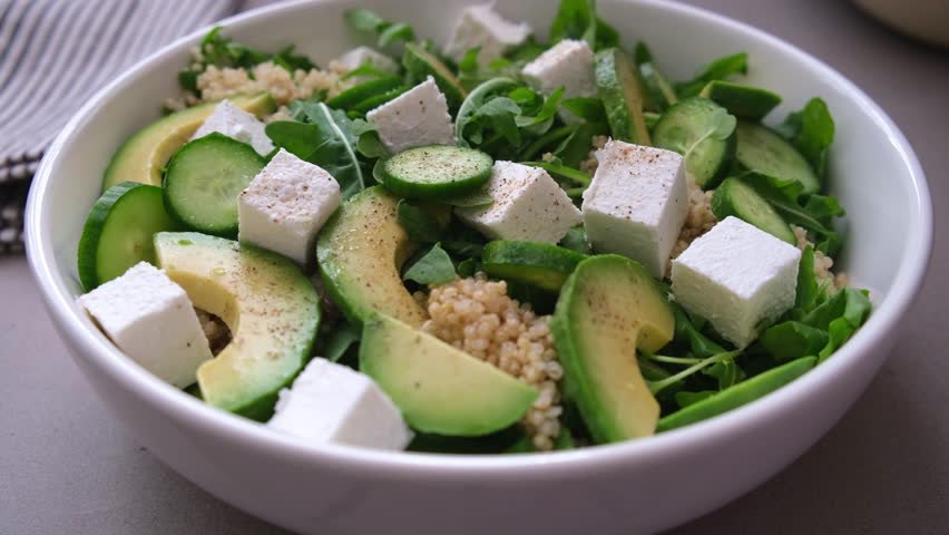 Green quinoa salad with cucumber, arugula, avocado and feta.