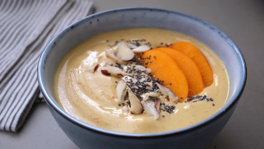 Persimmon smoothie bowl with chia seeds and nuts.