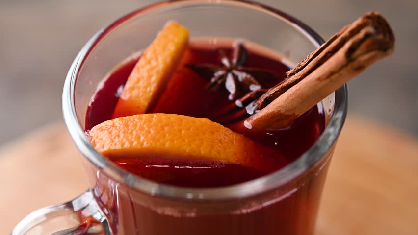 Mulled Wine with Orange and Cinnamon Sticks on wooden table. Close up