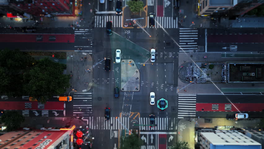 Aerial top down view of a city intersection with a digital overlay. Autonomous cars identified and tracked, showing data connection lines