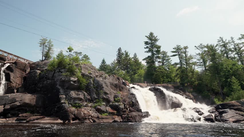 A static view of High Falls in Muskoka on a bright summer day with blue sky and trees in High Falls Park in Bracebridge, Ontario, Canada
