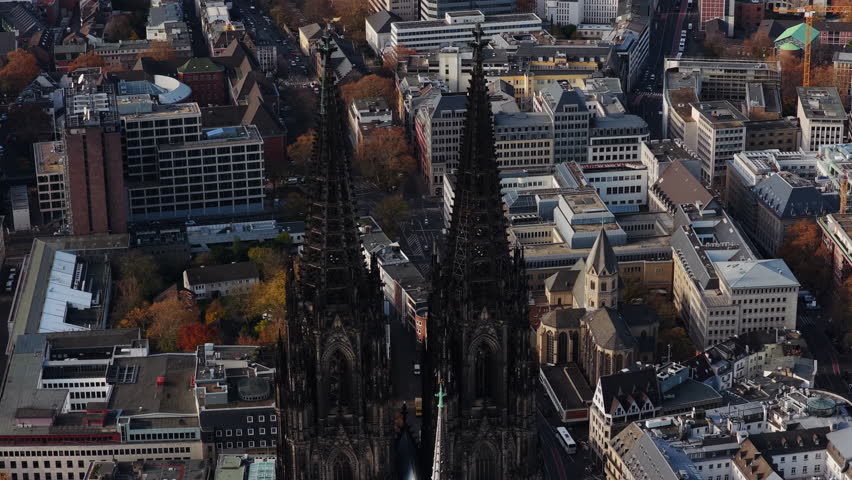 Aerial footage showing magnificent Gothic architecture of Cologne Cathedral and its surrounding urban landscape in autumn
