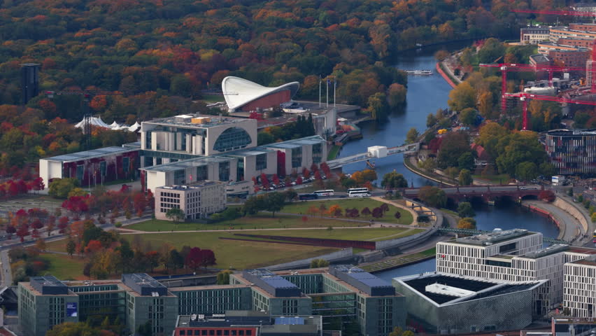Aerial video capturing German Chancellery, Spree River, and government district in Berlin on a vibrant autumn afternoon