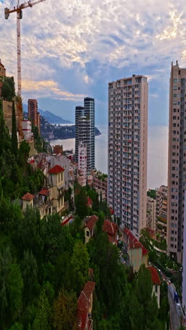  Aerial view of the city center of Monaco. Establishing shot showcases luxury yachts moored in Monaco Bay, the Palais Princier de Monaco, and luxury apartment buildings of Monte Carlo
