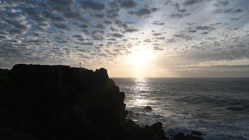 Warm evening light illuminates the Atlantic waves as they strike the steep rocky cliffs of Peniche, showing the dramatic power and natural beauty of the Portuguese coastline.