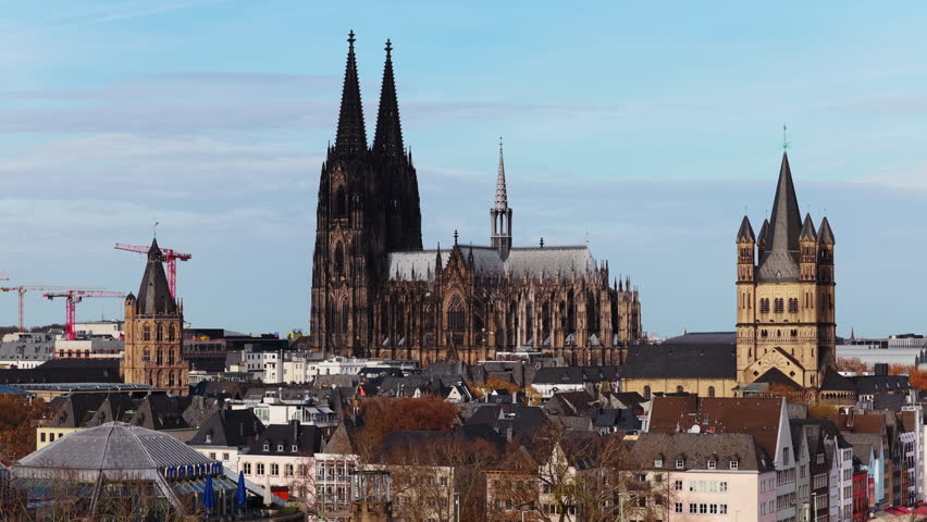 Tripod aerial establishing shot of old town cityscape of Cologne, Germany, featuring famous Cathedral and Great Saint Martin Church