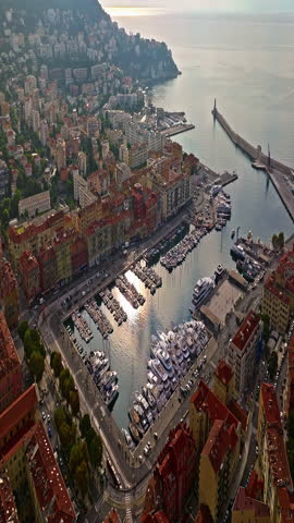  Aerial view of bustling beachfront promenade on sunny day. Beautiful panorama in Nice, France. Palm trees, old houses in old town azure sea and green hills. Summer in French Riviera