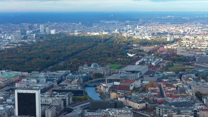 Aerial perspective of Berlin, Germany, iconic Reichstag Building and Government buildings, Spree river, and vast Tiergarten park