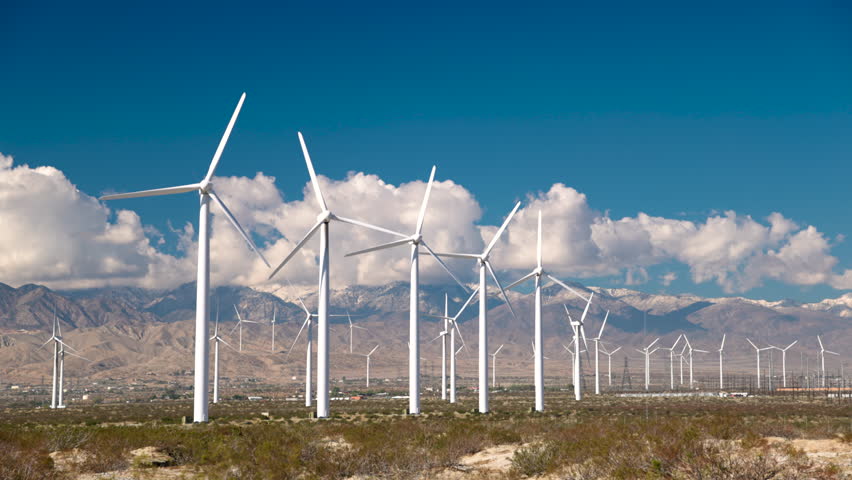 Static shot of wind turbines operating in the San Gorgonio Pass near Palm Springs, California. Renewable energy infrastructure in a desert mountain landscape under clear skies.