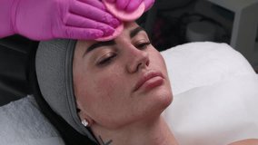 A woman receives a facial cleansing treatment with a white mask applied and removed by an esthetician wearing pink gloves. - Powered by Shutterstock - Get 15% off with code: PIKWIZARD15